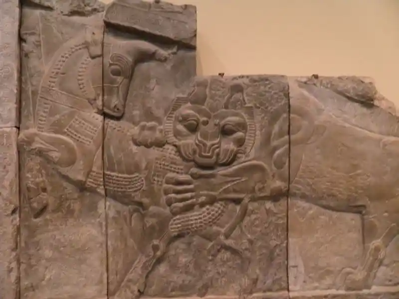 Lion biting the backside of a bull relif